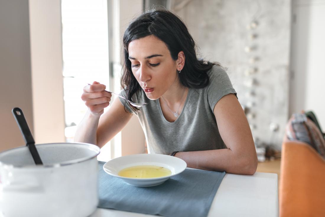 a woman eating soup